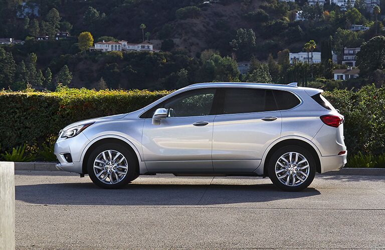 2019 Buick Envision exterior side shot parked on a veranda as a forest rests in the background on hills