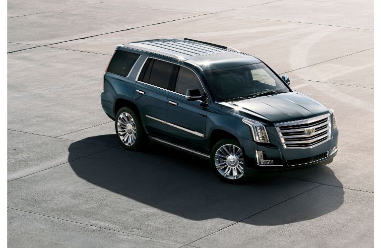 2020 Cadillac Escalade exterior overhead shot with deep blue paint color framed by a sun and shadow