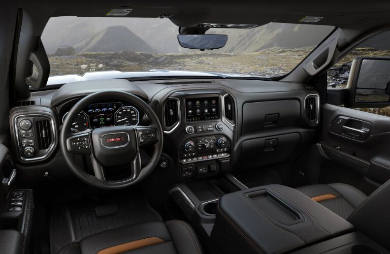2020 GMC Sierra 2500HD AT4 interior shot of front seating, steering wheel, and dashboard layout