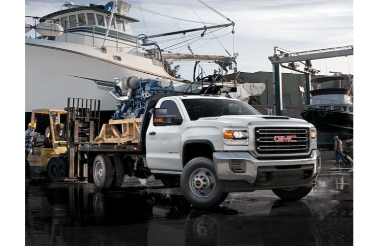 GMC Business Elite Sierra custom construction work model parked outside a boat yard