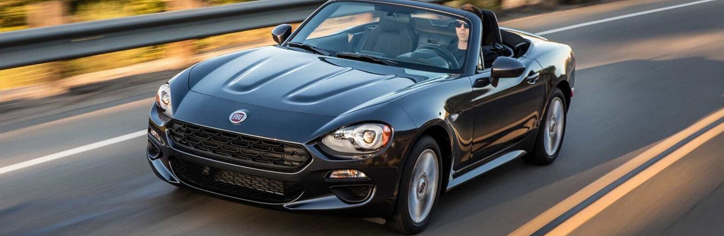black fiat 124 spider driving on a road