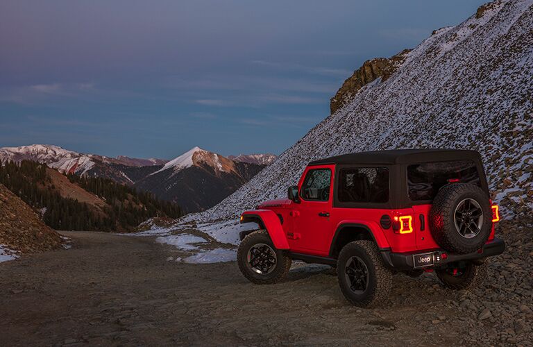 rear quarter view of a 2018 Jeep Wrangler at the base of a mountain