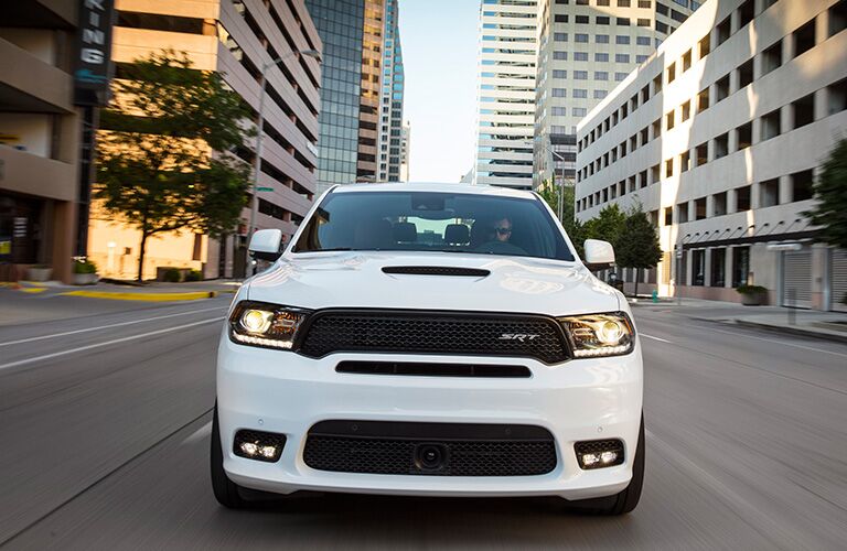 2019 Dodge Durango SRT exterior front shot with white paint color driving through a city during the day