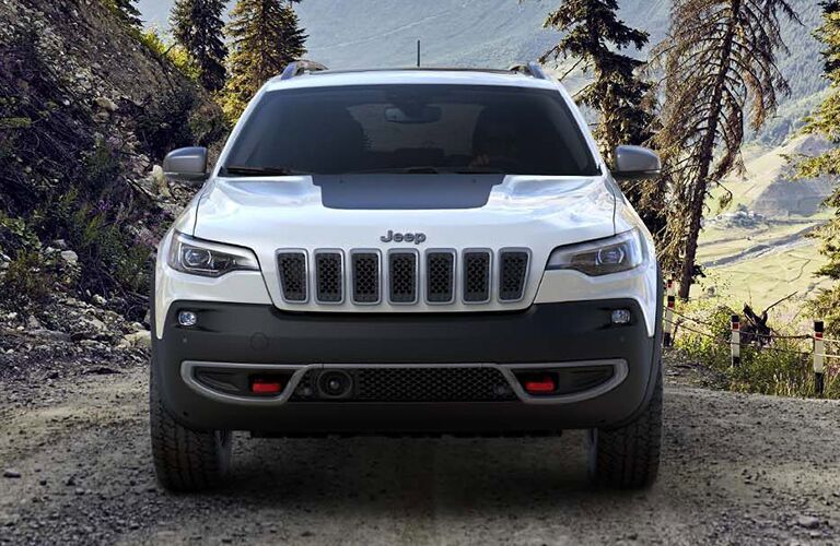 White 2019 Jeep Cherokee driving through woods