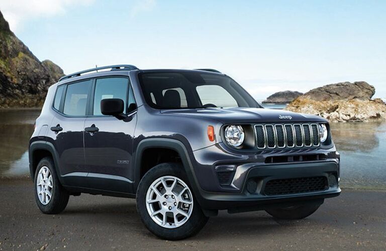 2019 Jeep Renegade exterior shot parked on a beach near water and giant rocky cliffs and formations