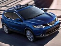 Exterior view of a blue 2017 Nissan Rogue Sport driving down the highway