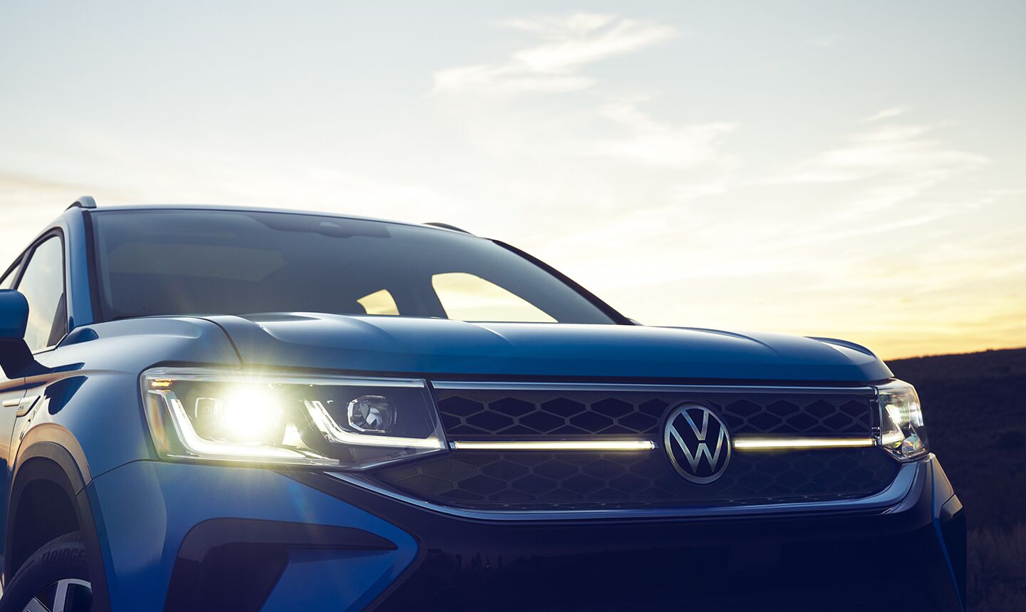 The front grille of a VW Taos at sunset.
